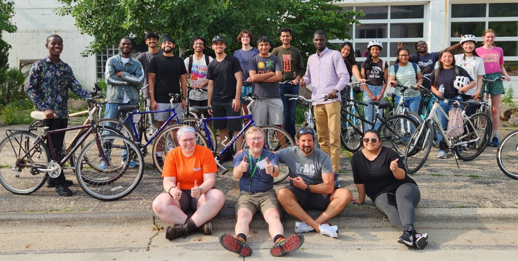 We-Cycle community photo with volunteers and bikes outside their workshop